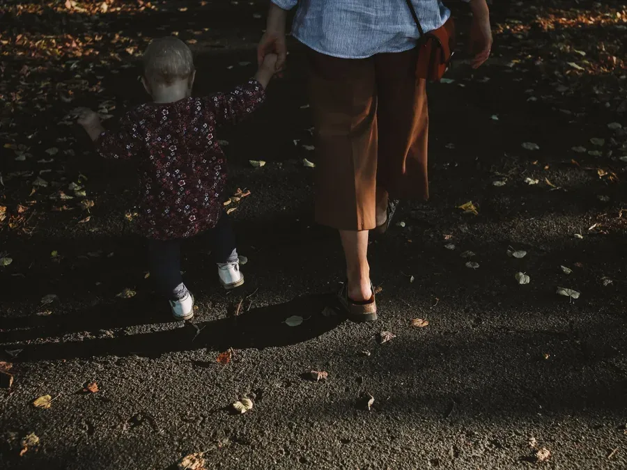 Adulte et enfant assis par terre, mains posées sur des blocs de bois lors d'un jeu